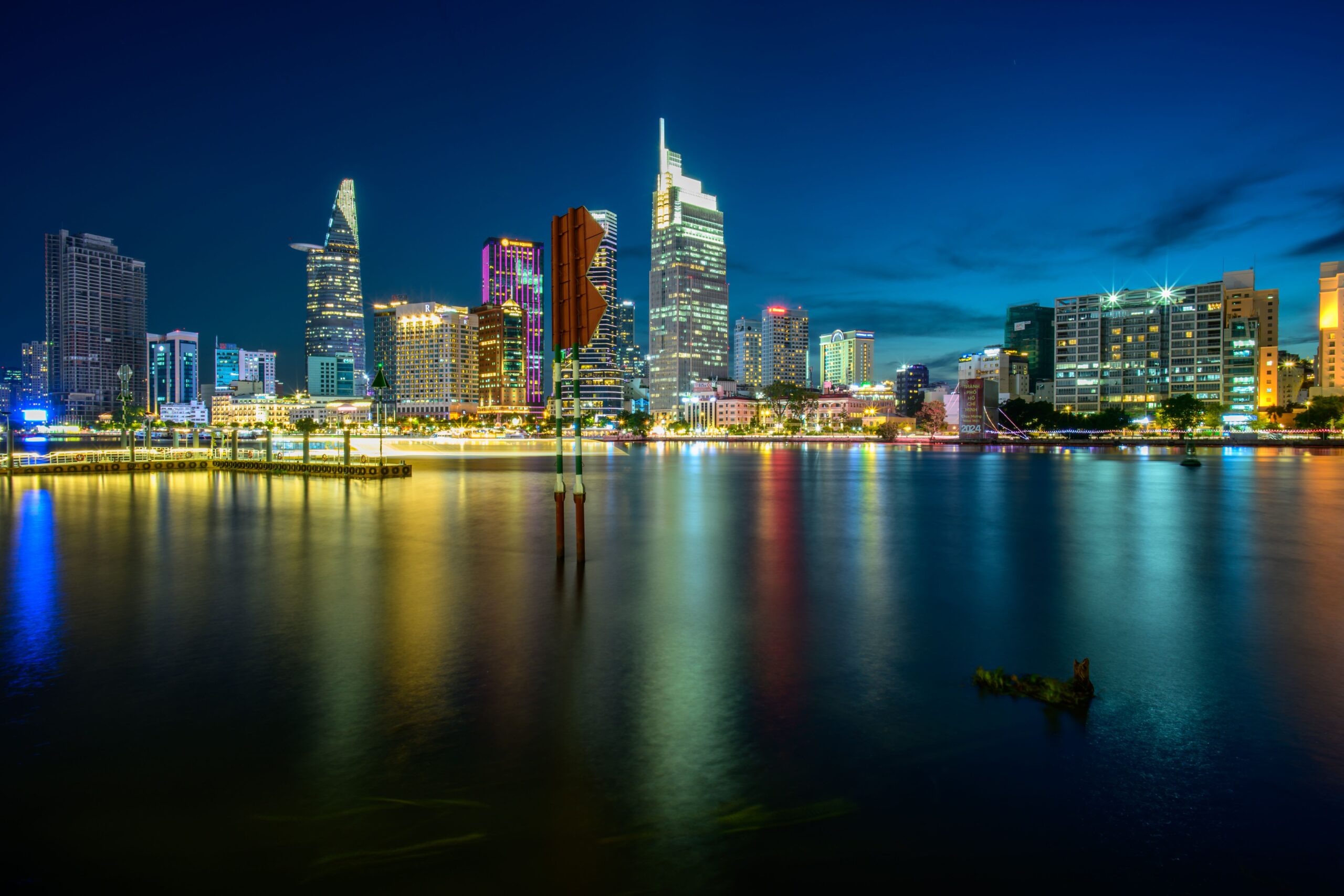 Stunning night view of Ho Chi Minh City's skyline reflecting on the Saigon River.